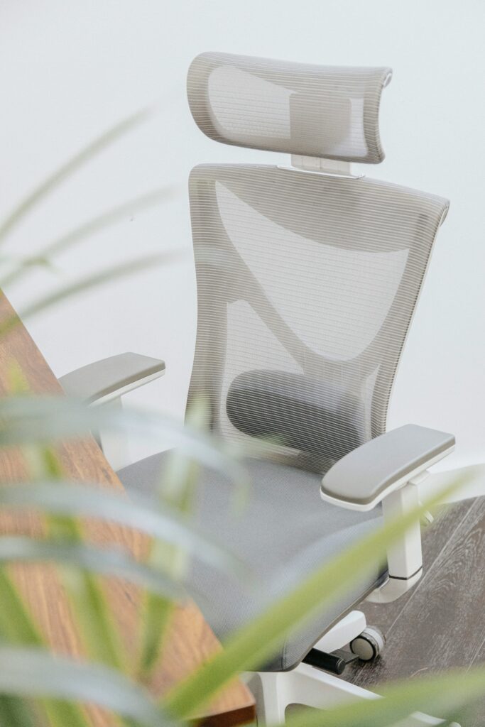 Weißer ergonomischer Bürostuhl mit Rückenlehne in hellem Office