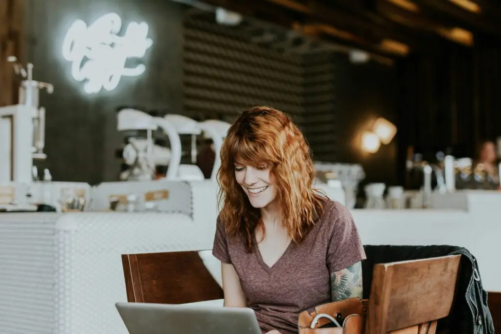 Zufriedene Arbeitnehmerin im Café mit Homeoffice-Pauschale